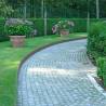 bordure de jardin en acier corten brut délimitant une allée pavée dans un jardin avec du gazon en partie gauche